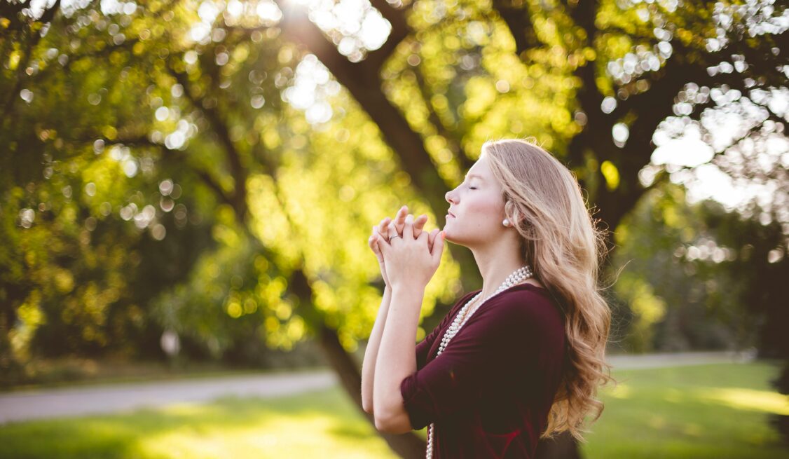 Blond woman praying faithfully
