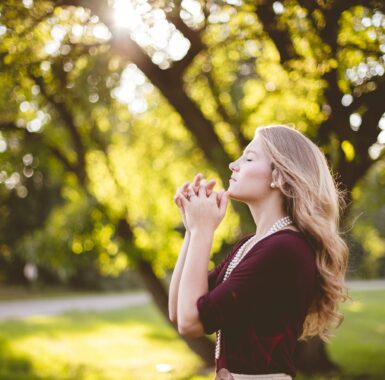 Blond woman praying faithfully