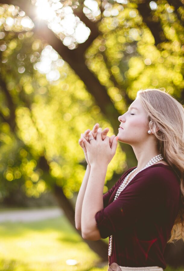 Blond woman praying faithfully