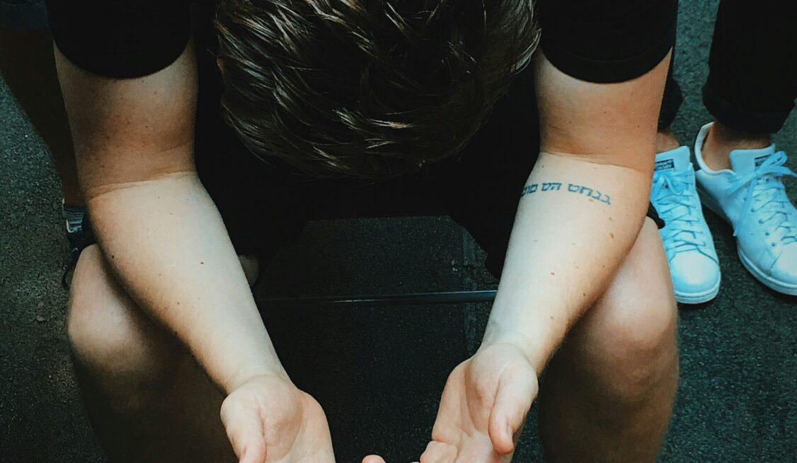 Young man praying, surrounded by peers