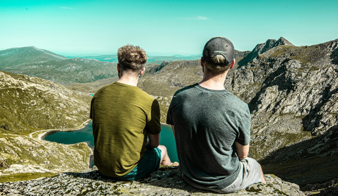 Two men looking over a cliff