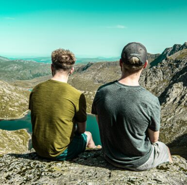 Two men looking over a cliff