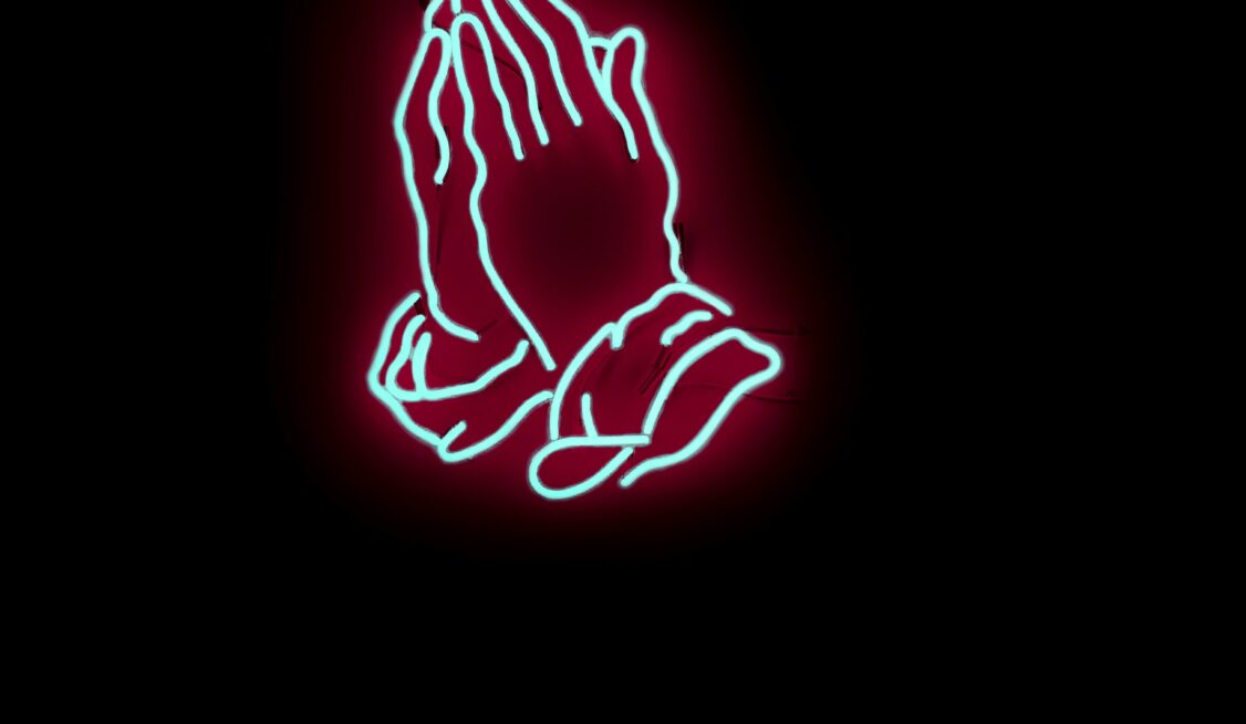 Neon light fixture of two hands praying