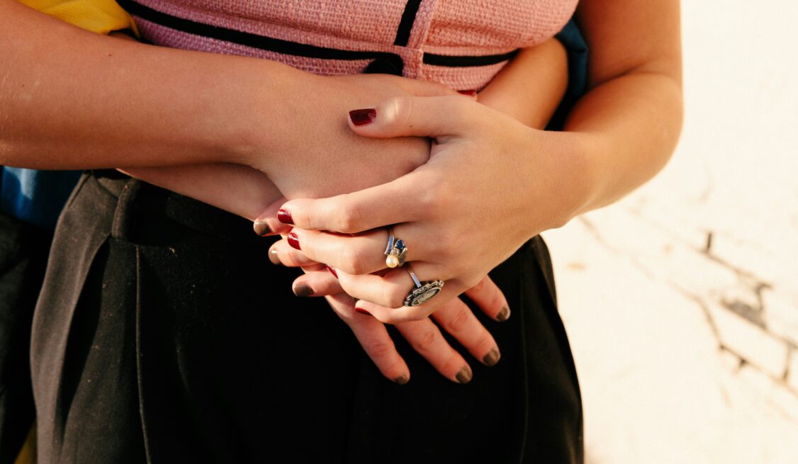 A woman's body being hugged with hands clasped together