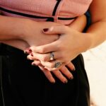 A woman's body being hugged with hands clasped together