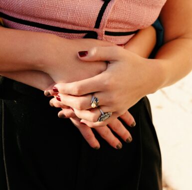 A woman's body being hugged with hands clasped together