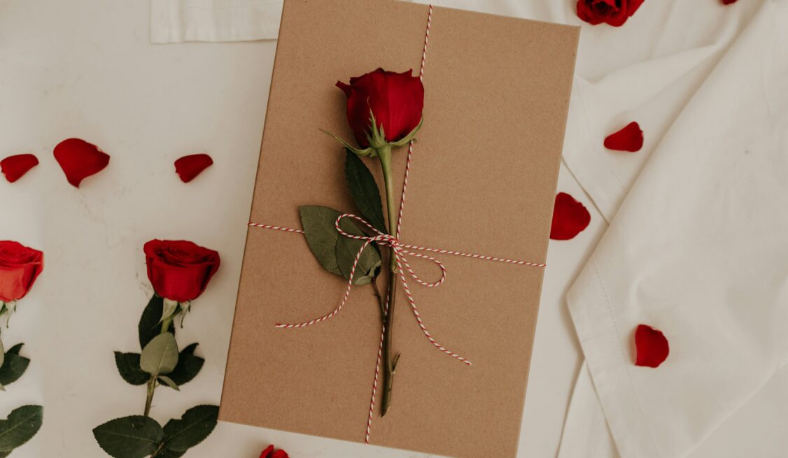 Single red rose on a brown envelope